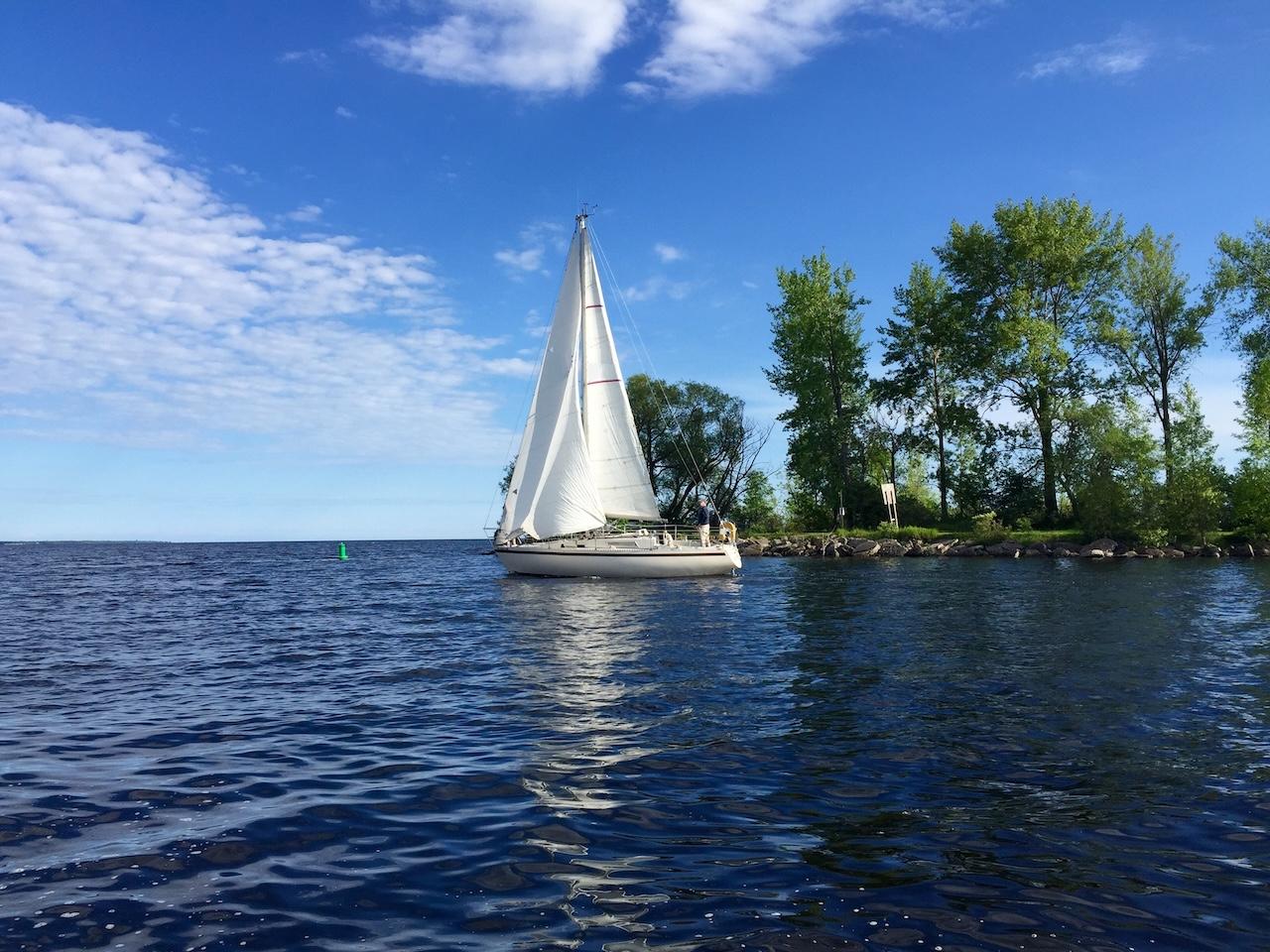 Sail boat departing the yacht harbor in Escanaba, MI.