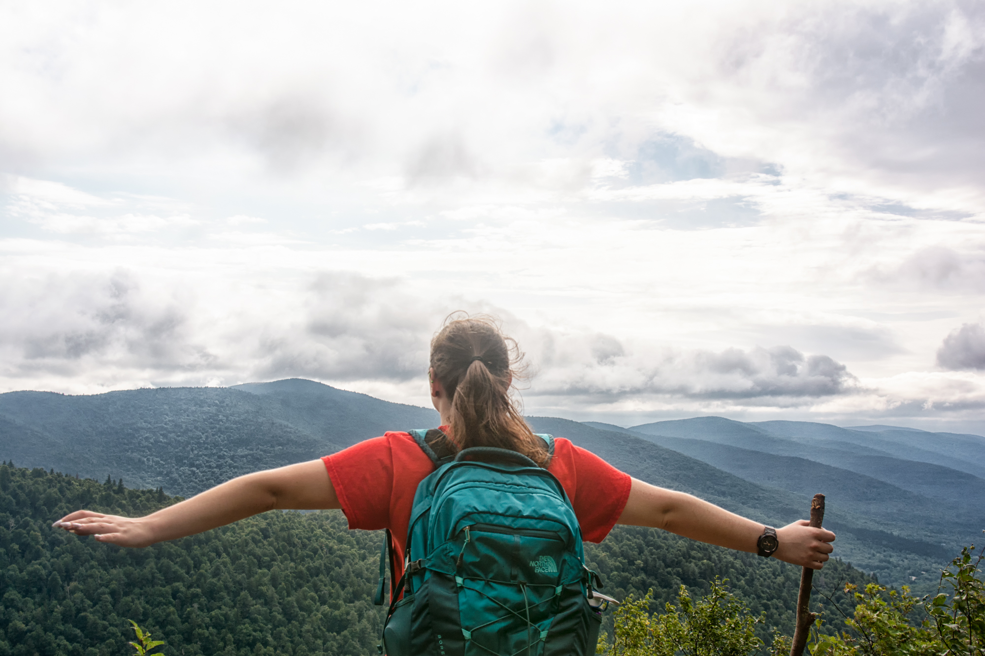 A woman at the summit of Hunter Mountain hiking trail in the Catskills, NY, USA.